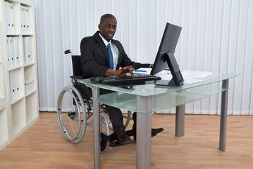 Businessman Working In Office Sitting On Wheelchair