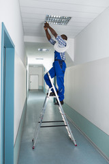 Electrician Installing Light On Ceiling