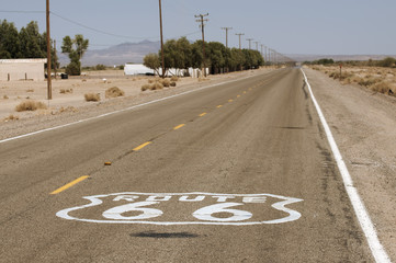 Route 66 signe de la chaussée lever du soleil dans le désert de Mojave en Californie.