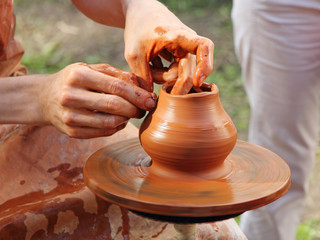 Fototapeta na wymiar Potter makes on pottery wheel clay pot.