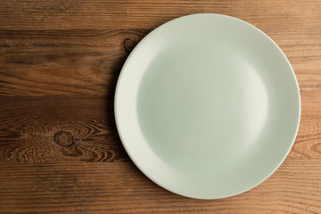 The soft green ceramic plate on the wooden ground