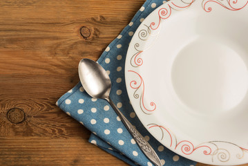 Ceramic plate on the wooden table with blue tablecloth