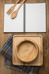 Notebook and wooden kitchenware in kitchen workplace