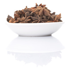 Star anise spices in white bowl over white background