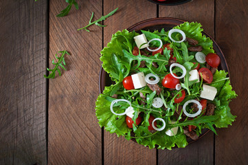Salad with veal slices, arugula, tomatoes and feta cheese