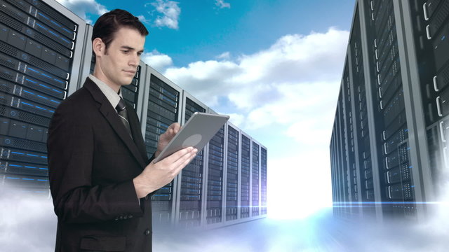 Businessman using tablet computer in front of server tower on sky background