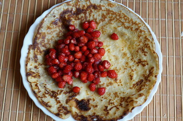 Pancakes with red fresh forest wild strawberry