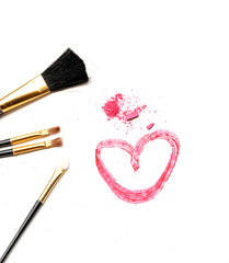 Cosmetic brush and pink powder on white background