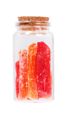 Red and orange dried papaya slices in a glass bottle with cork s