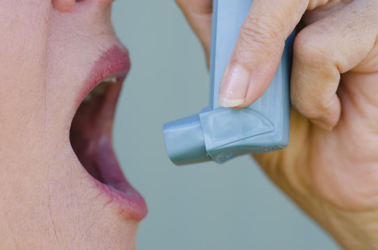 Detail image woman with asthma using inhaler