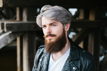 Bearded hipster with nose ring in leather jacket