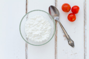 Cottage cheese in a bowl on a vintage wood background