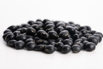 A lot of black soybeans on wooden background