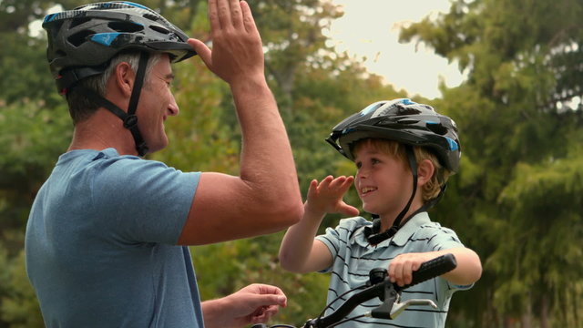 Happy father on a bike with his son