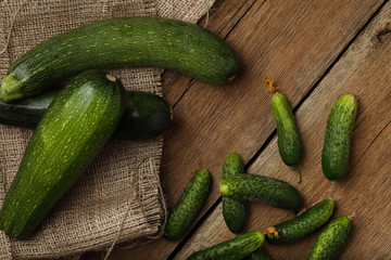 Zucchini and cucumbers on wooden background. Top view.