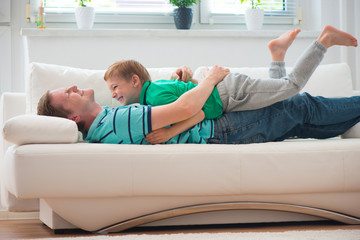 Little boy having fun with father at home