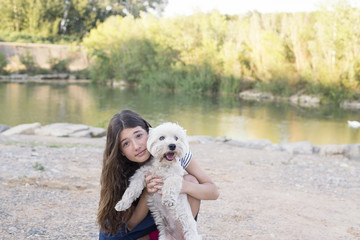 Teen in the park by the river girl with her dog