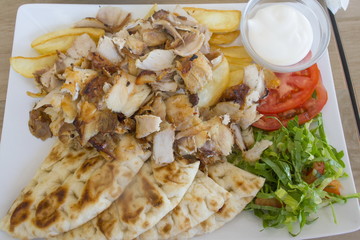 Chicken gyros portion  with vegetables served on a plate