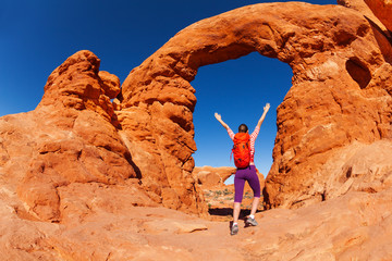 Woman with arms up walking to the arches Utah