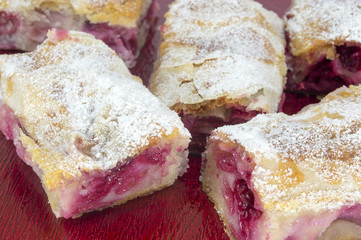 Homemade cherry pie covered with sugar and decorated with raw ch