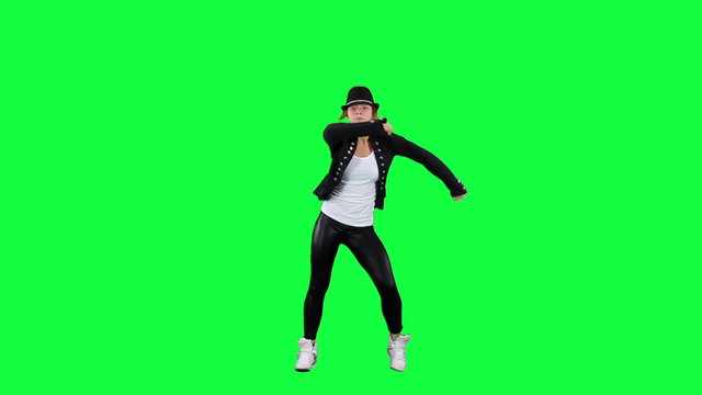 Girl in the hat dancing like the king of pop. Chroma key background. Young woman dancing against a green background
