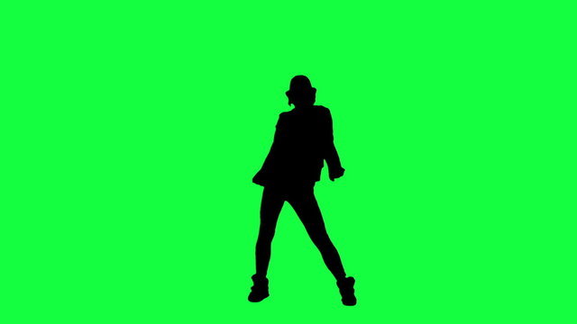 Silhouette of a girl in the hat dancing like the king of pop. Chroma key background. Silhouette of a woman dancing against a green background

