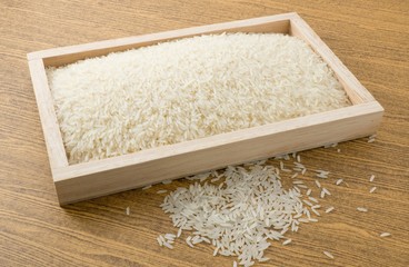 Uncooked Jasmine Rice in Brown Wooden Tray