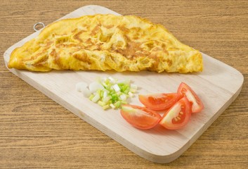 Thai  Omelette with Tomatoes and Scallion on Wooden Board