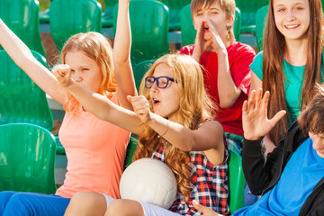 Teenagers cheer for team during game at stadium