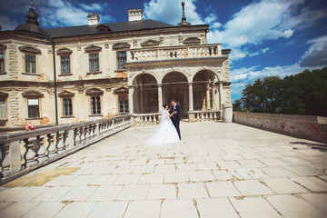 Obraz premium young wedding couple next to castle, outside portrait