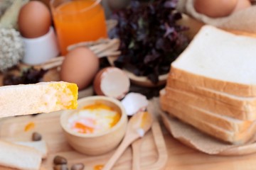 soft-boiled egg with bread on wood background.