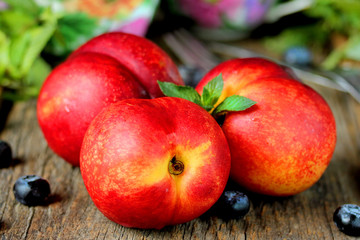 Three nectarines on the wooden table