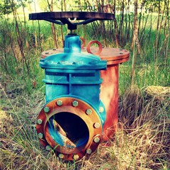 Old expansion pipe of drink water pipes joined with new blue valve and new blue joint members. New dump valve.  Extreme kind of corrosion, metal corroded texture.