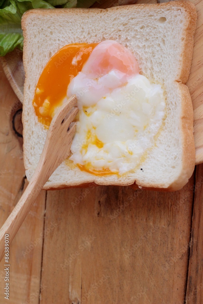 Poster soft-boiled egg with bread on wood background.