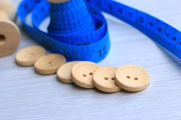 Measure tape and bobbin and wood buttons.