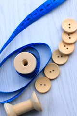 Measure tape and bobbin and wood buttons.