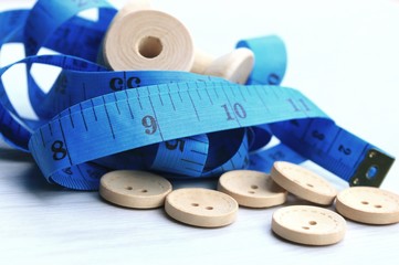 Measure tape and bobbin and wood buttons.