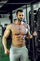 Fototapeta na wymiar Man posing in gym showing abs
