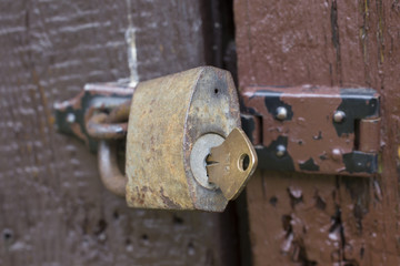 Wooden door with the old iron padlock