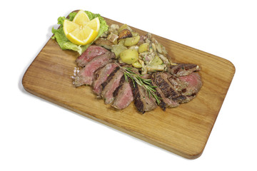 Sirloin with mushrooms and potatoes on a wooden cutting board