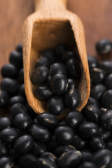 A lot of black soybeans on wooden background