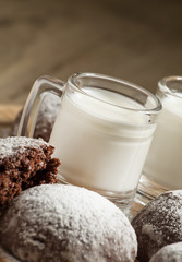 Homemade chocolate cookies sprinkled with powdered sugar and mil