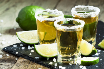 Gold Mexican tequila with lime and salt, selective focus