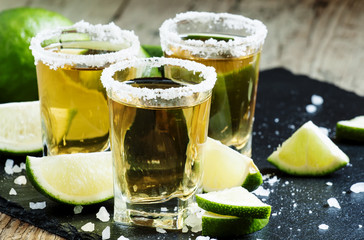 Gold Mexican tequila with lime and salt, selective focus