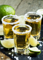 Gold Mexican tequila with lime and salt, selective focus