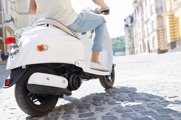 Close up of man driving scooter. © zinkevych
