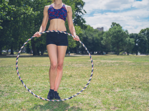 Fit woman in park with hula hoop