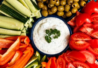 board of vegetables and garlic sauce in the middle