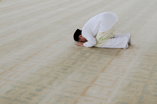 man praying, man prostrating during prayers