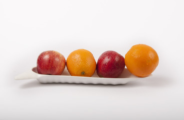 apple and orange fruits on plate like a boat with white background